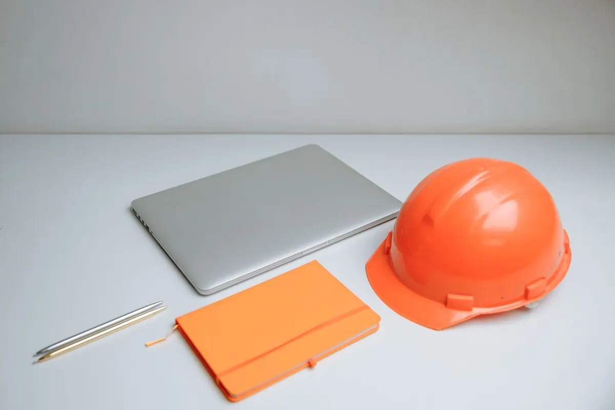 Contractor office desk with laptop and hard hat