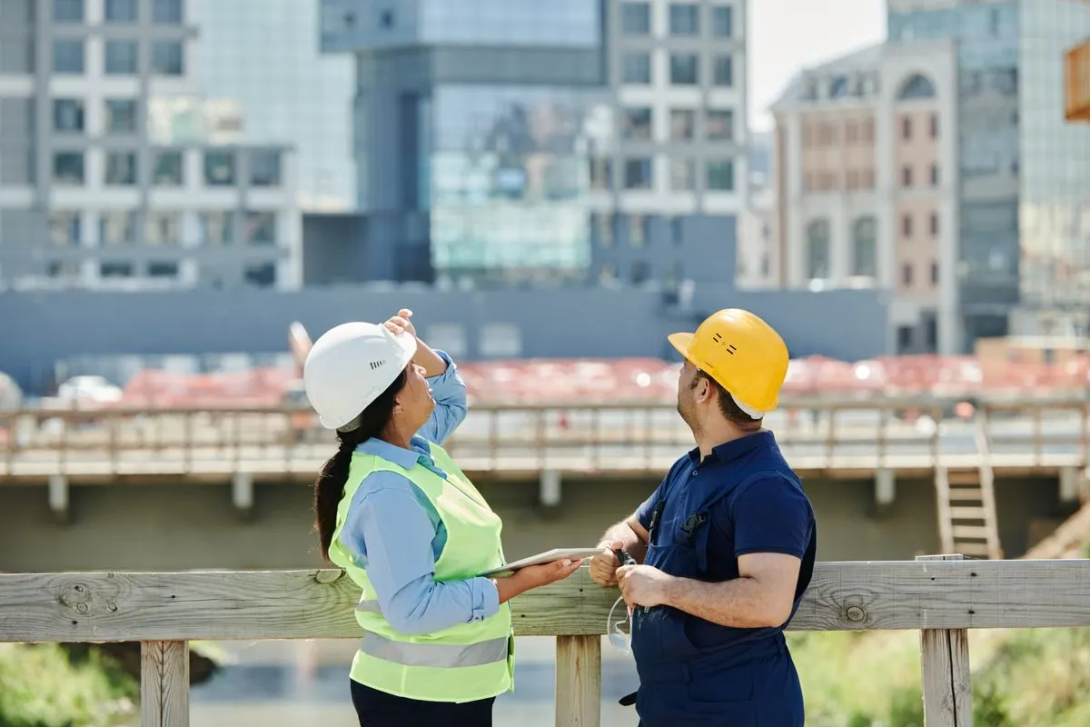 Two construction workers reviewing a tablet on a job site