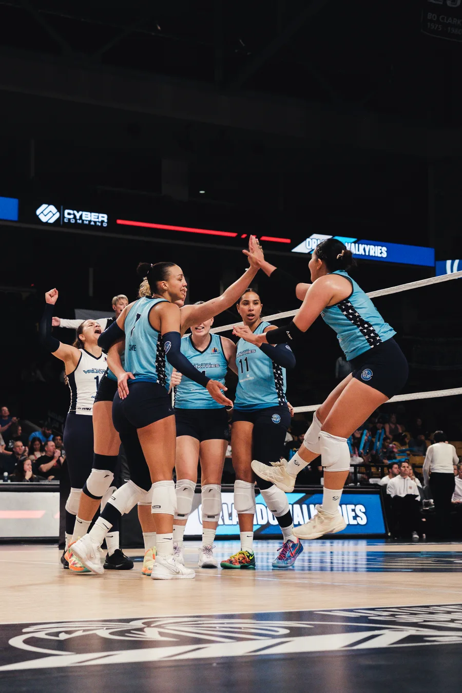 Orlando Valkyries celebrating a point beneath the Cyber Command board
