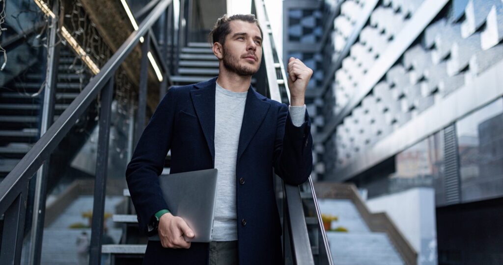 a male cybersecurity specialist in a business suit on the background of the stairs of an office