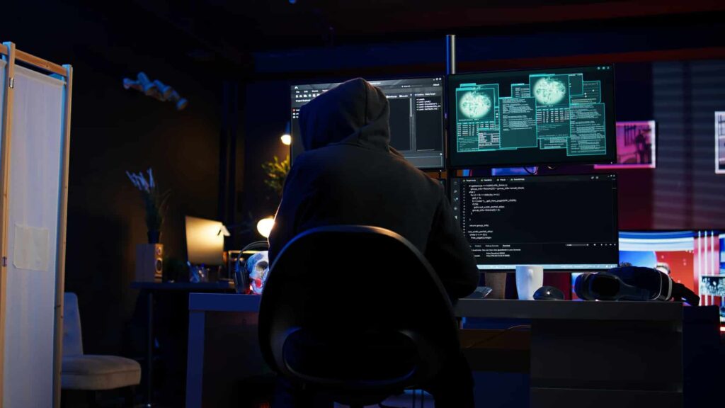 Hacker breaking down security systems defenses using rogue scripts
