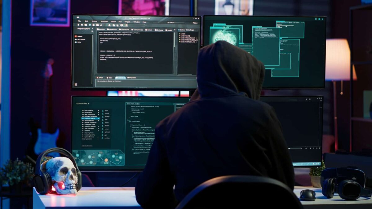 Hacker breaking down security systems defenses using rogue scripts