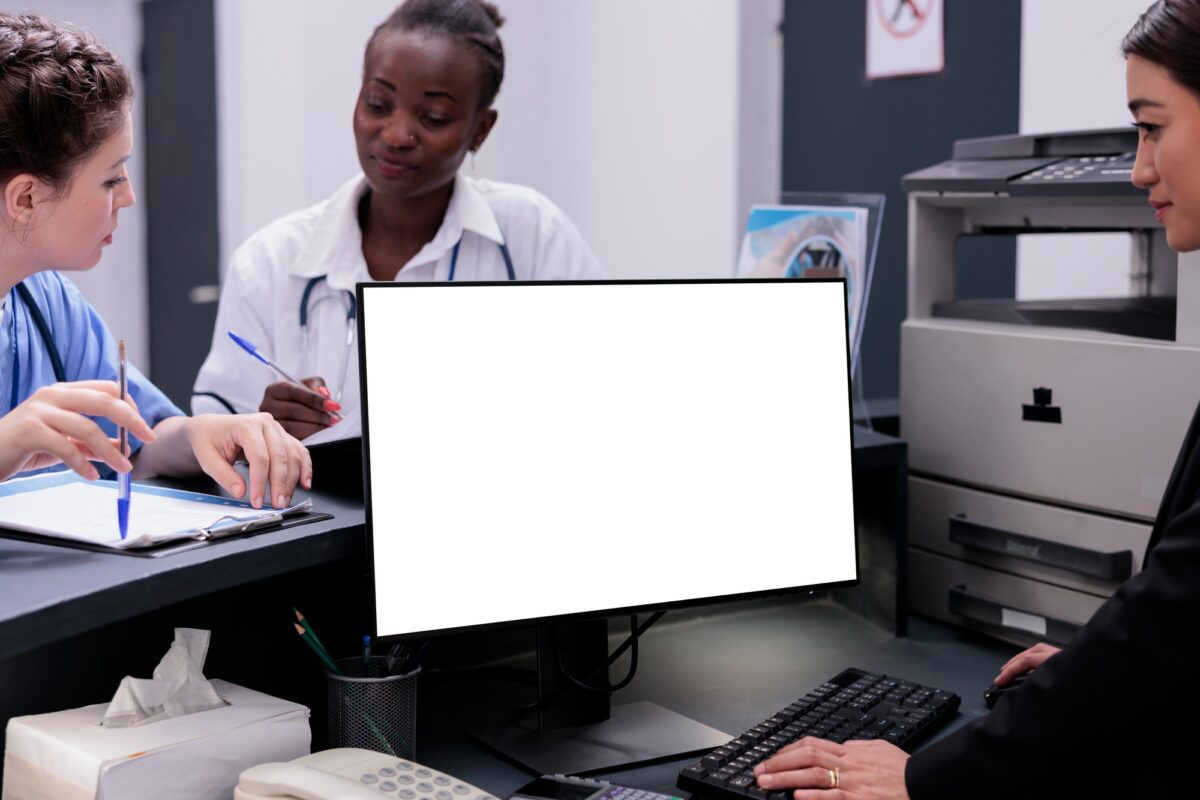 Receptionist manages patient records and schedules appointments typing medical data on computer