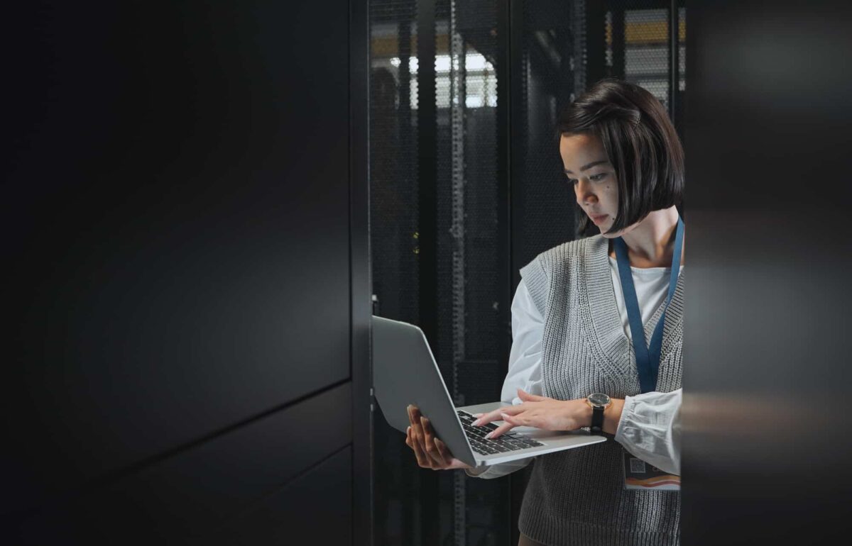 Woman with laptop, datacenter and information technology, engineer and server room with software up