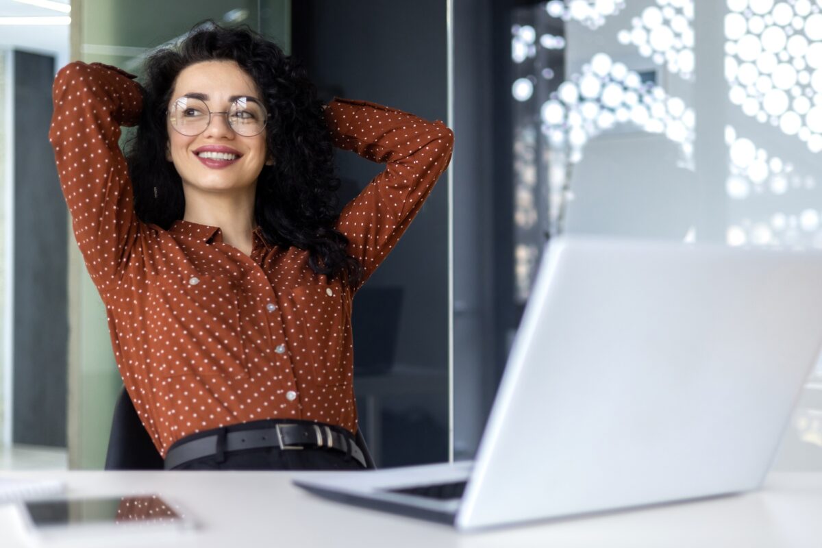 Young woman engineer developer programmer works in the office inside the IT company, satisfied with